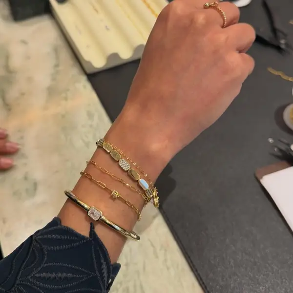 Gold welded bracelets stacked on a wrist