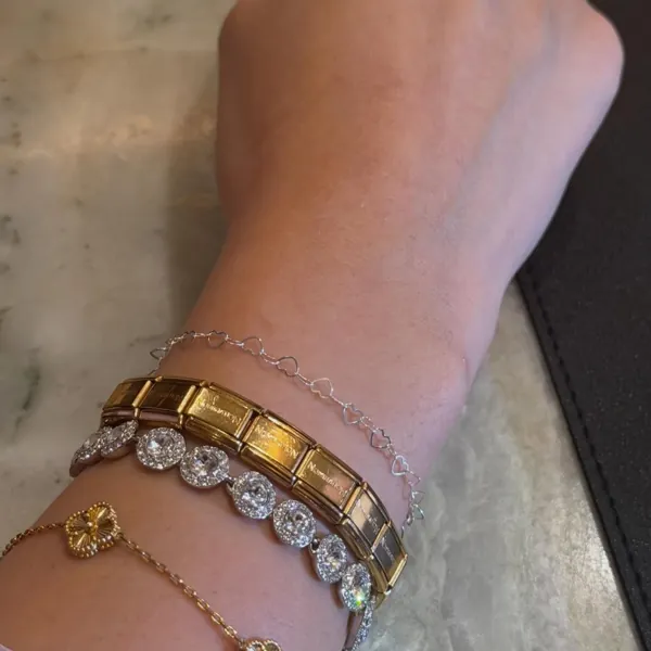 A stack of welded chains with a gold watch strap